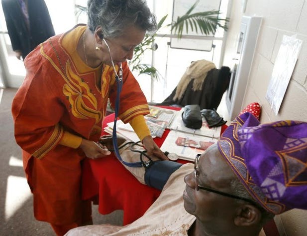 Woman takes blood pressure at health clinic.