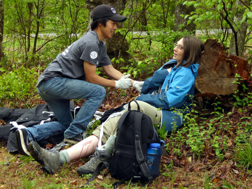 Students practicing first aid during class.  One learns a lot playing the role of patient, too.