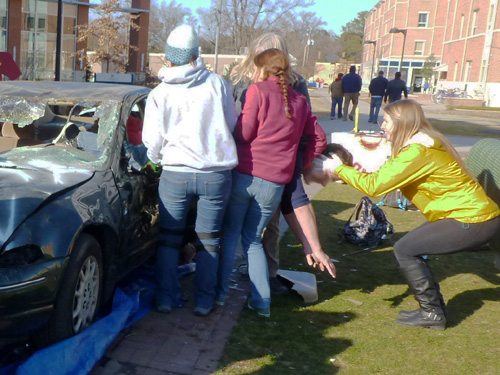 Skills learned apply to car crashes and all kinds of situations necessitating first aid, as shown here where students practice extricating a patient from a crashed car.