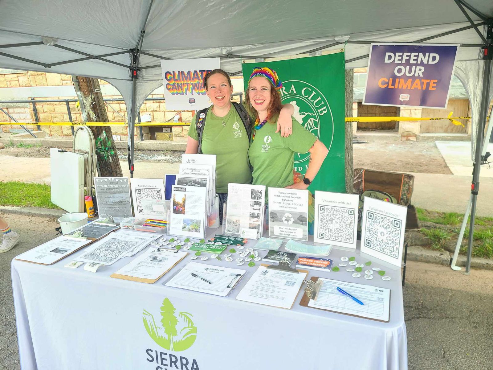 Two volunteers tabling at a Pride festival