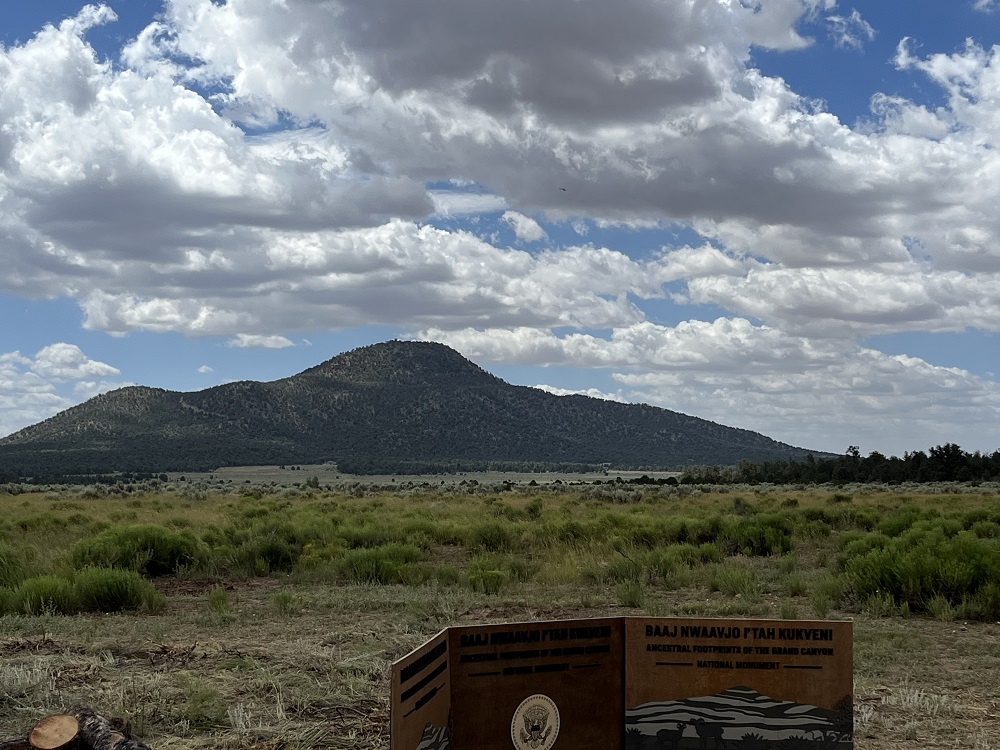 a sign for the new national monument with a butte in the background