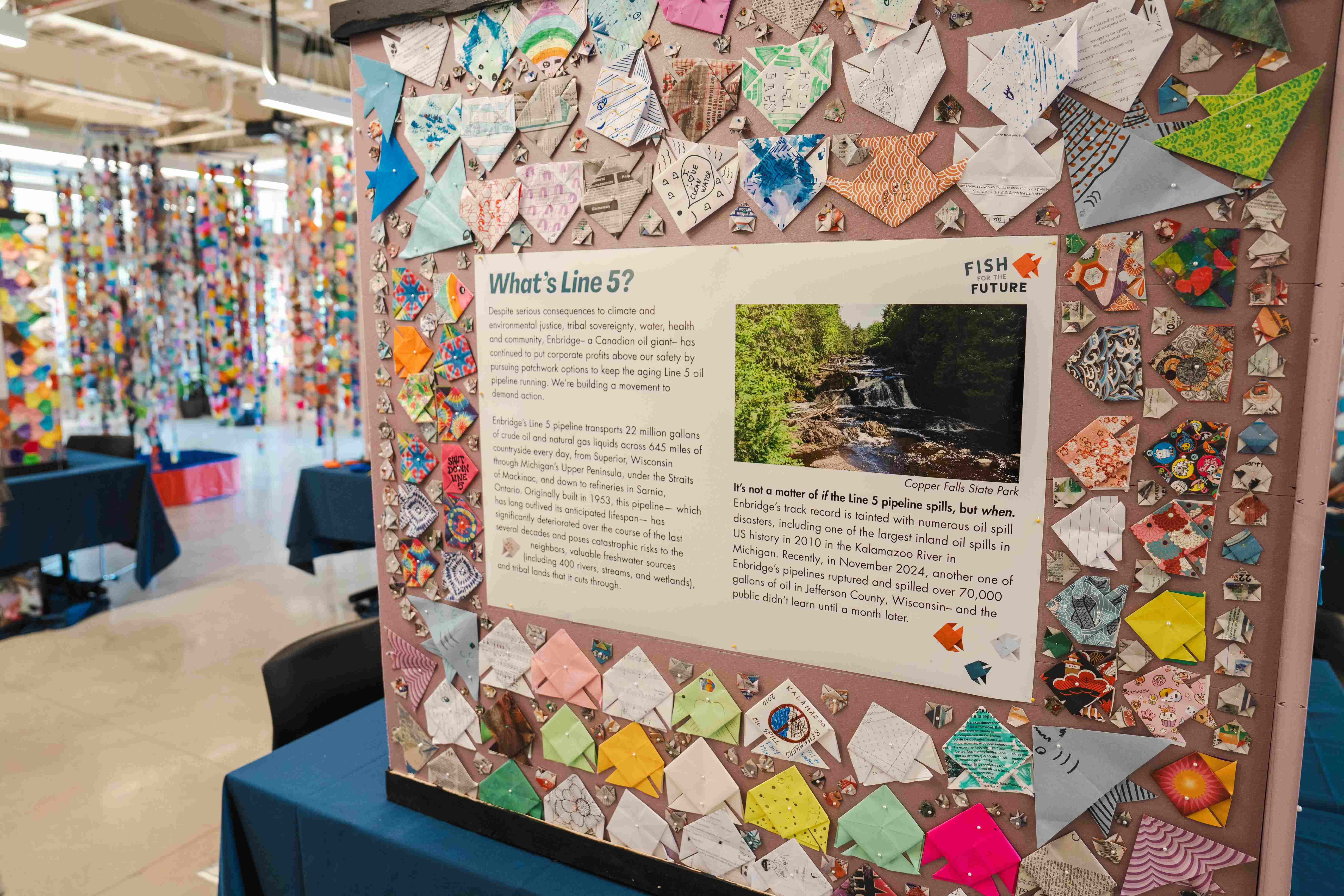 Fish for the future kiosk display with What is Line 5 poster surrounded by origami fish