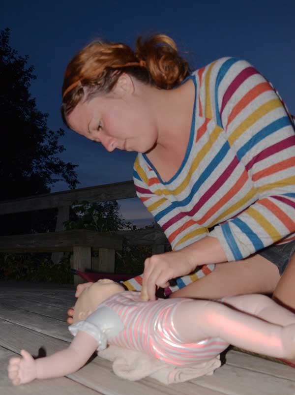 Student practicing CPR on an infant manikin